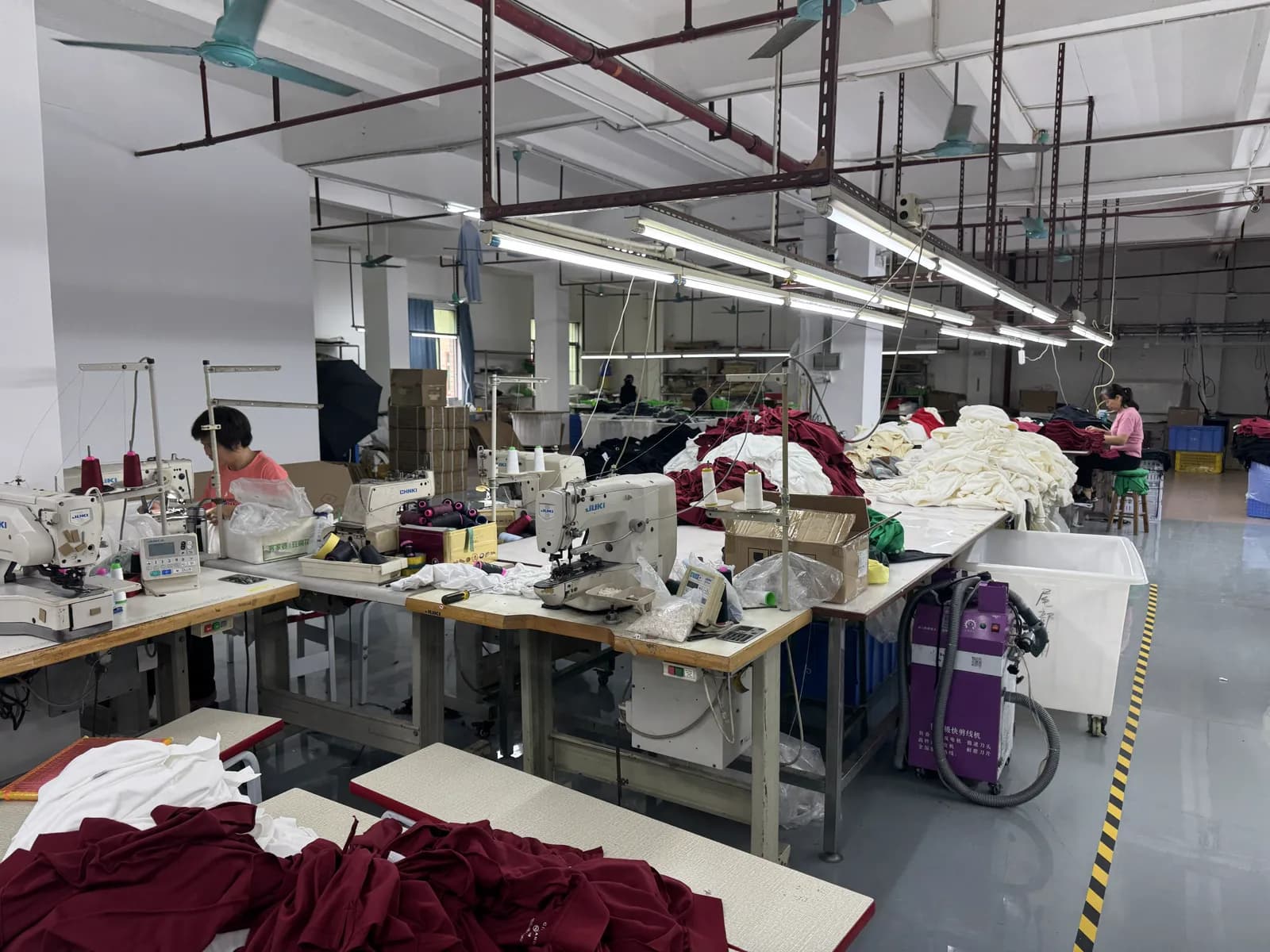 Workers sewing garments on industrial machines at Pindon's Dongguan clothing factory