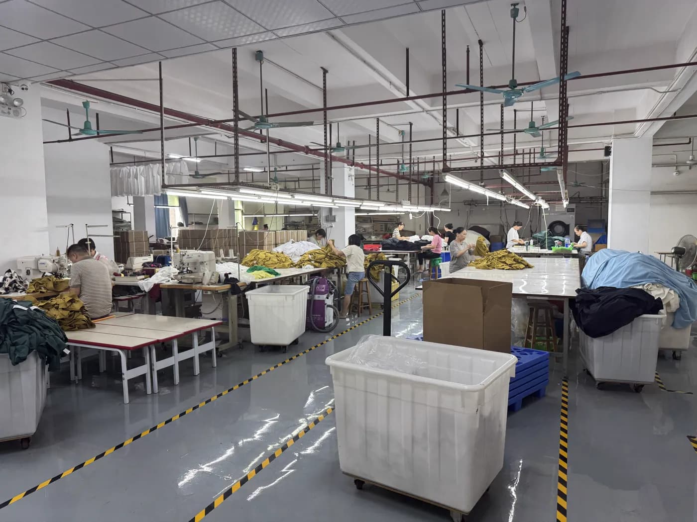 Workers handling yellow and olive garment lots on the factory floor
