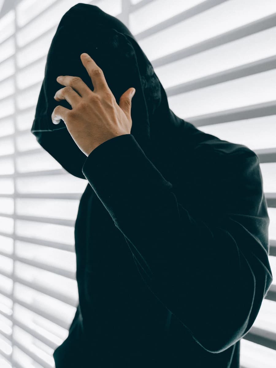 Adult model style reference — person wearing green hooded jacket inside room
