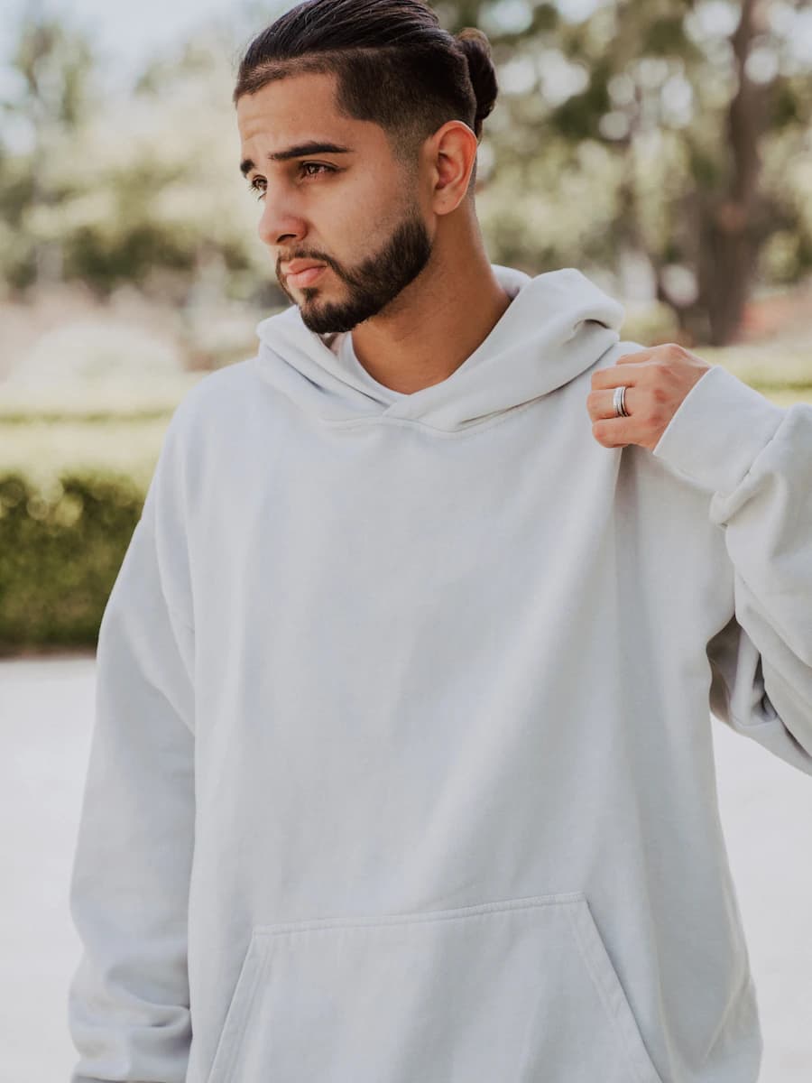 Adult model style reference — a man with a beard wearing a white hoodie