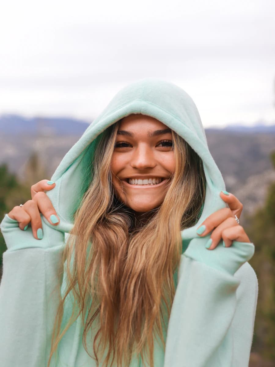 Adult model style reference — smiling woman in white hoodie