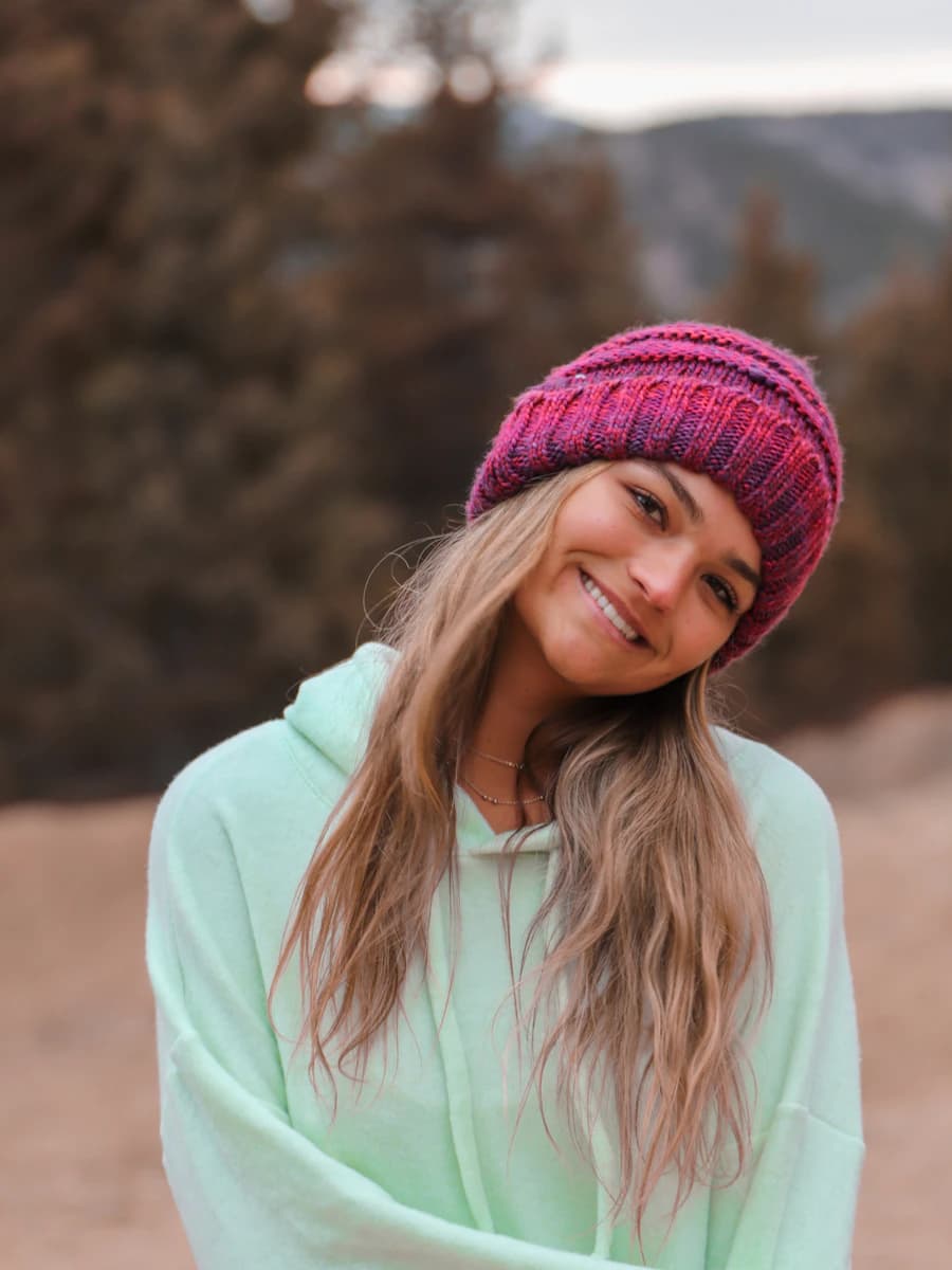 Adult model style reference — woman in pink knit cap and pink hoodie