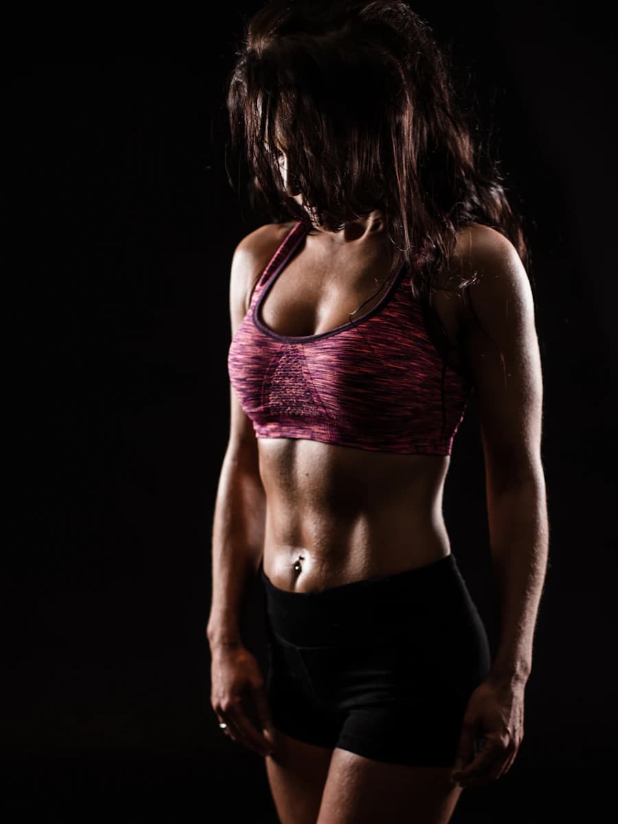 Adult model style reference — Fit woman sports bra shorts black background