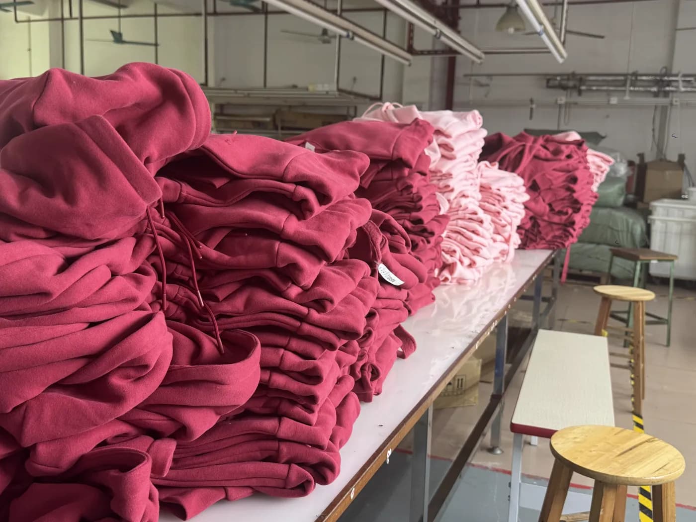 Stacked custom hoodies during bulk production at Pindon's Dongguan factory