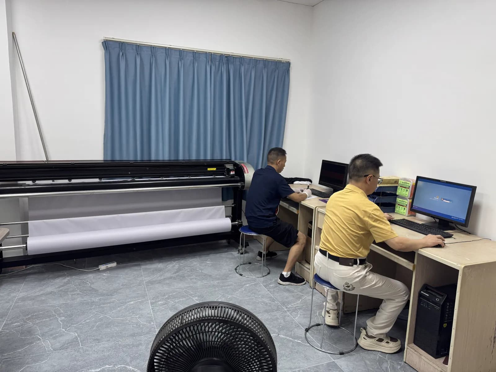 Sampling and pattern development desks beside a plotter at Pindon's Dongguan factory